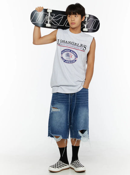 Men's Distressed Jorts IL509 Blue full-length front styling shot on male model holding skateboard overhead wearing white sleeveless graphic tee