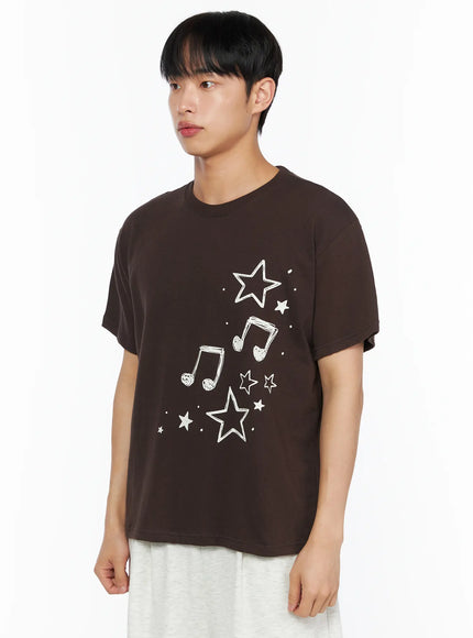 Men's Drawing Graphic Tee IL514 Brown side shot on male model turned slightly, close-up of star and music note graphic print detail on front