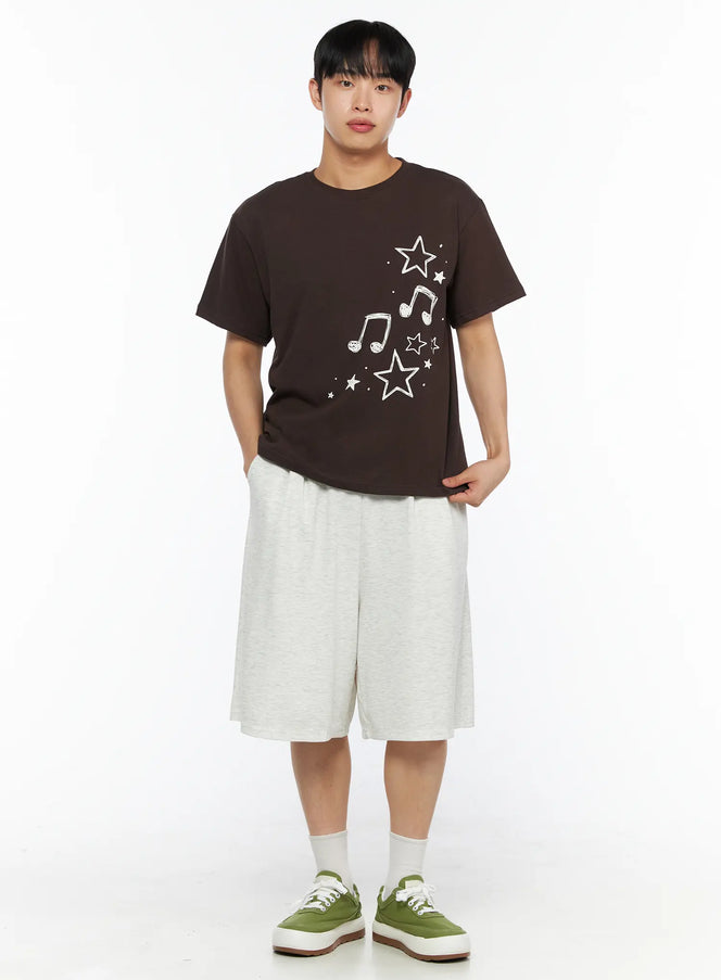 Men's Drawing Graphic Tee IL514 Brown full-body front shot on male model styled with light grey wide shorts and green sneakers