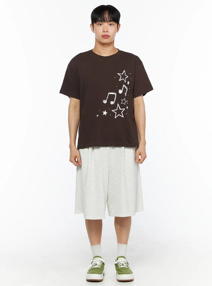 Men's Drawing Graphic Tee IL514 Brown full-body front shot on male model standing straight, white star and music note graphic print on chest