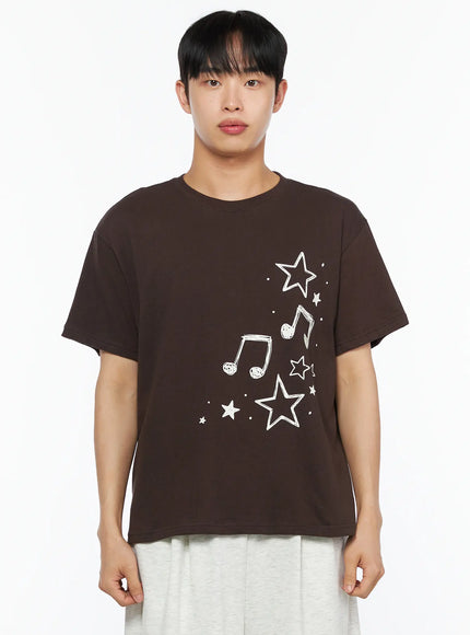 Men's Drawing Graphic Tee IL514 Brown close-up front shot on male model showing white star and music note graphic print, crew neck detail