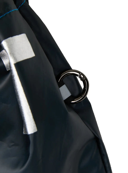 Men's Drawstring String Bag IL510 Navy close-up detail of side metal ring clasp hardware against glossy navy nylon fabric with silver letter print