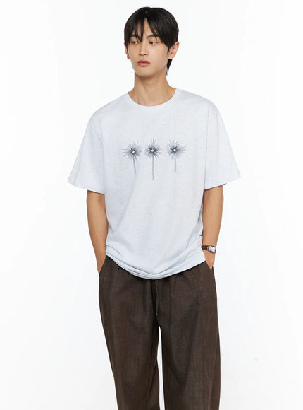 Men's Embroidered Graphic Tee IL528 Light Gray front shot on male model gazing aside hands in pockets three starburst chest embroidery melange texture