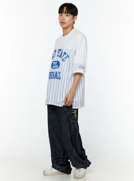 Men's Embroidered Wide Leg Jeans IU529 Dark blue three-quarter side view full-length on male model, styled with white Volt State Football jersey and white sneakers