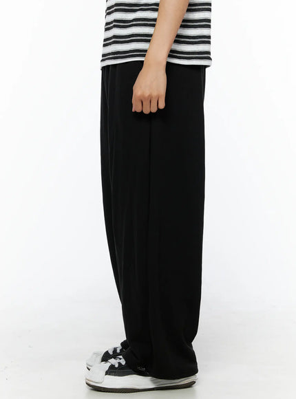 Men's Flame Wide Sweatpants (Black) IL514 side view on model showing full wide-leg length and relaxed silhouette with striped tee and sneakers