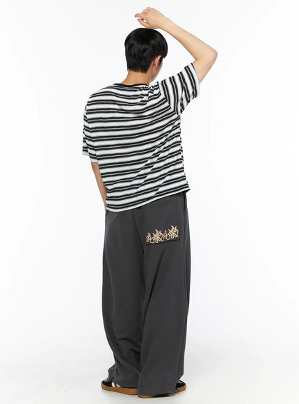 Men's Flame Wide Sweatpants (Dark Gray) IL514 Dark gray full back view on male model with raised arm, wide-leg silhouette styled with stripe tee