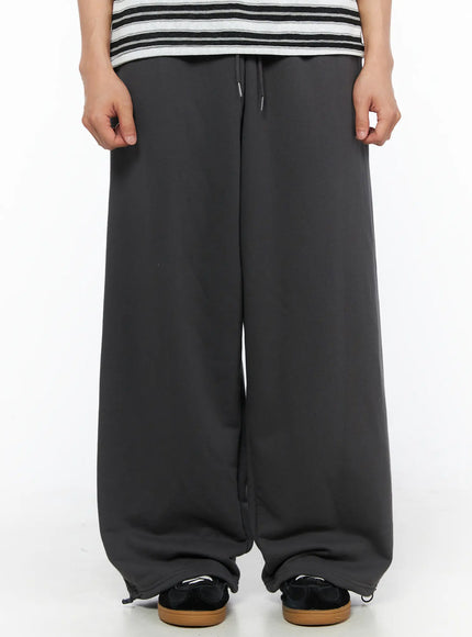 Men's Flame Wide Sweatpants (Dark Gray) IL514 Dark gray front close-up on model showing drawstring waistband and ultra wide-leg fleece pants from waist to hem