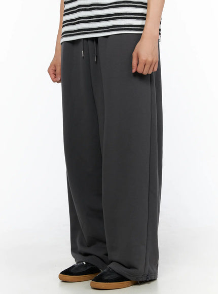 Men's Flame Wide Sweatpants (Dark Gray) IL514 Dark gray side close-up on model showing drawstring waist and straight wide-leg profile with sneakers at hem