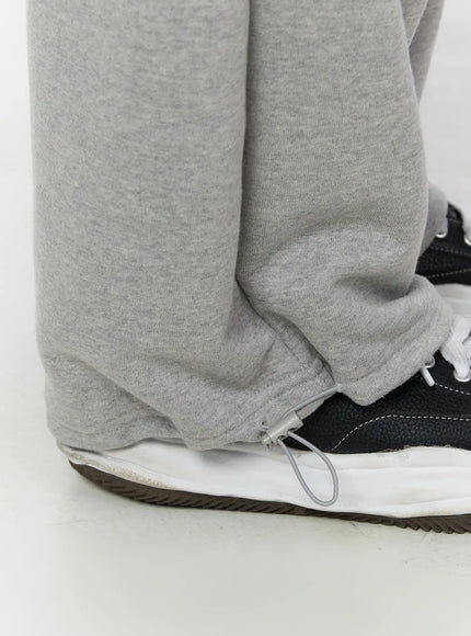 Men's Flame Wide Sweatpants (Gray) IL514 Gray close-up detail of hem zipper toggle adjustable drawcord at ankle cuff with sneaker styling
