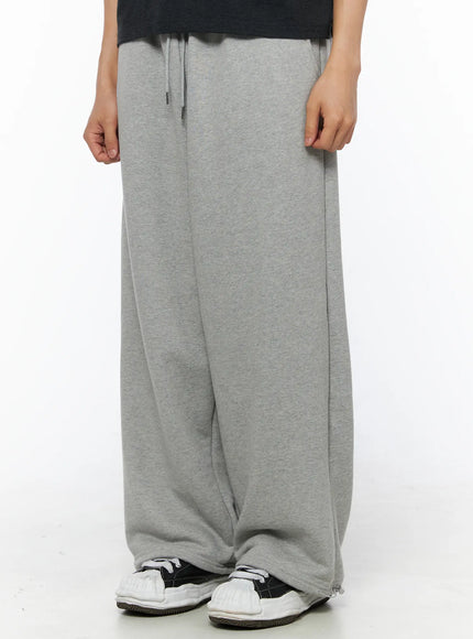 Men's Flame Wide Sweatpants (Gray) IL514 Gray front lower-half close-up on model showing voluminous wide leg and ankle hem pooling over sneakers