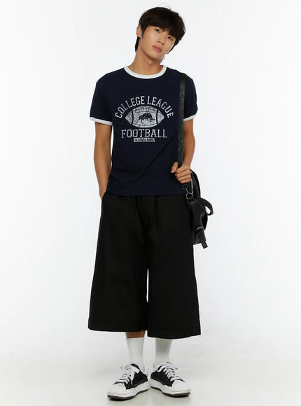 Men's Football Graphic T-Shirt IL513 Dark blue full-body front shot on model holding black crossbody bag hands in pockets styled with wide shorts
