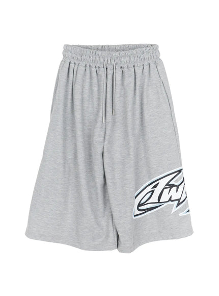 Men's Graphic Logo Shorts (Gray) IL502 Gray flat-lay front view showing elasticized drawstring waist, wide-leg cut, bold black and blue graphic logo print on right hem