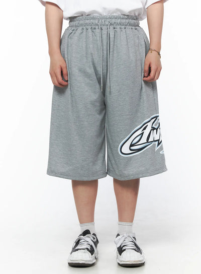 LEWKIN Men's Graphic Logo Shorts (Gray) IL502 Gray M/L front view on model wearing white tee, elasticized drawstring waist, bold graphic logo print on hem