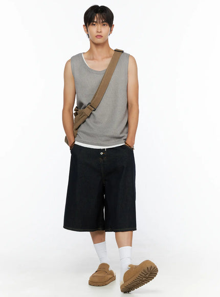 Men's Graphic Loose-Fit Shorts IL515 Dark blue full-length front view on male model in grey waffle tank with crossbody bag and loafers, wide-leg denim shorts with hands in pockets