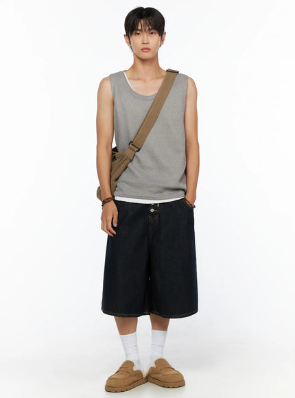 Men's Graphic Loose-Fit Shorts IL515 Dark blue full-length front view on male model in grey waffle tank and crossbody bag standing straight, wide-leg dark denim shorts with loafers