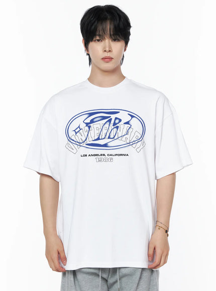 Men's Graphic Oversized T-Shirt IL502 White close-up front shot on male model, bold blue oval varsity graphic print, Los Angeles California 1986 text, crew neck cotton tee