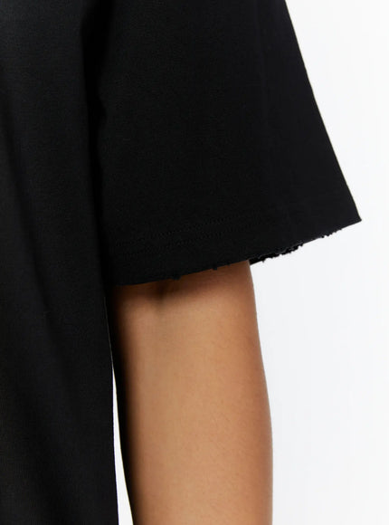 Men's Graphic Oversized T-Shirt IL515 Black close-up detail shot showing raw-cut short sleeve hem edge and heavyweight cotton fabric texture