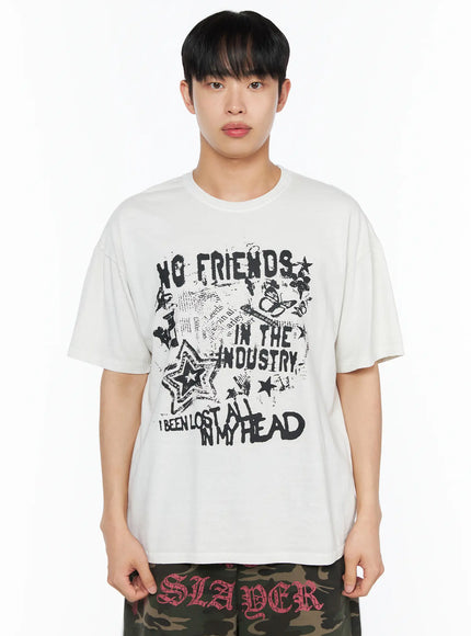 Men's Graphic Pigment Dyed Tee IL514 Light beige close-up front shot on male model showing No Friends In The Industry graphic with stars and butterfly print detail