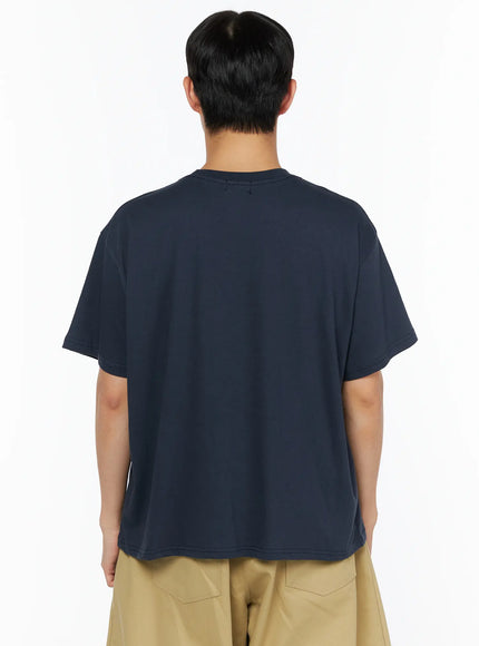 Men's Graphic Pocket Tee IL514 Navy back view on male model showing clean plain back panel, dropped shoulders and boxy cotton cut paired with khaki shorts