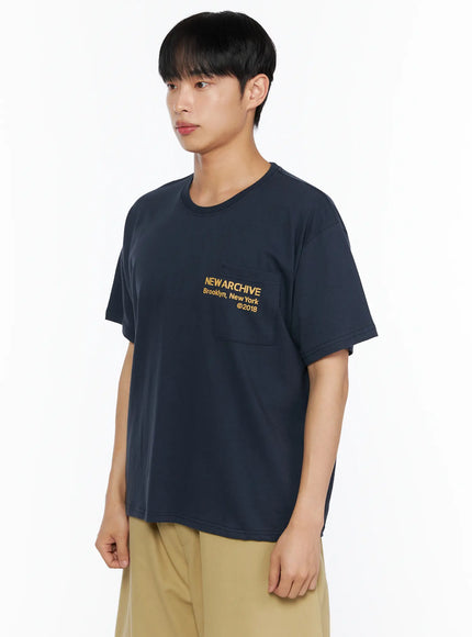 Men's Graphic Pocket Tee IL514 Navy side view on male model showing left chest NEW ARCHIVE Brooklyn New York ©2018 yellow graphic print and chest pocket detail