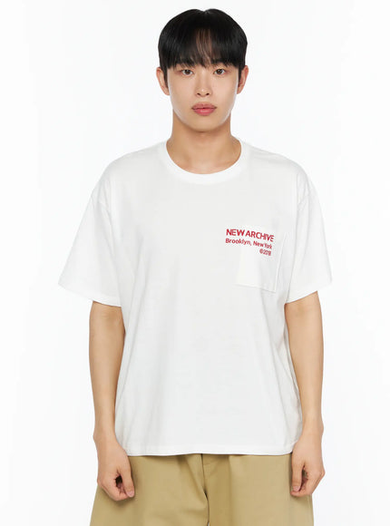 Men's Graphic Pocket Tee IL514 White close-up front view on male model showing red NEW ARCHIVE Brooklyn New York ©2018 chest pocket print and oversized cotton jersey fabric