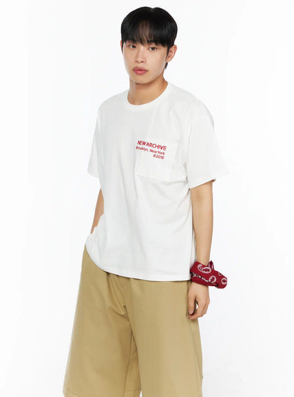 Men's Graphic Pocket Tee IL514 White side-angle view on male model with red paisley wrist bandana, showing chest pocket and red NEW ARCHIVE Brooklyn New York ©2018 print