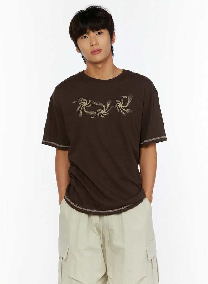LEWKIN Men's Graphic Print T-Shirt IL513 Dark brown front view on male model hands in pockets paired with beige cargo shorts cotton fabric