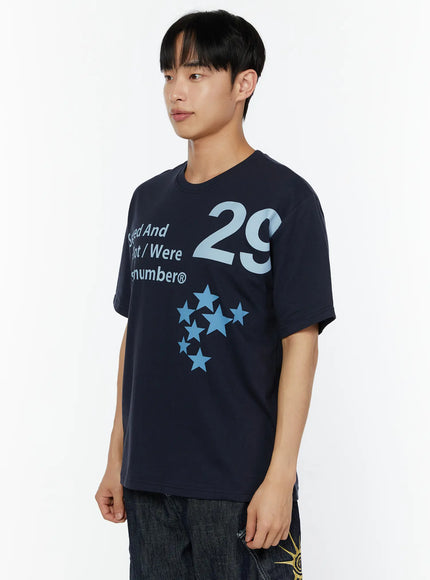 Men's Graphic Print T-Shirt IU529 Navy front close-up shot on male model showing 29 numeral, Served And All Got Were Stars:number® text and blue star cluster graphic detail