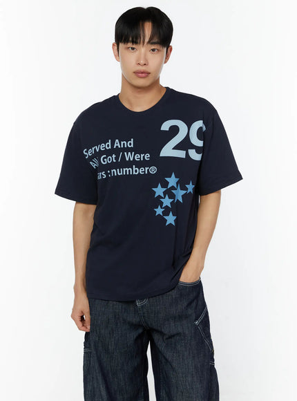 Men's Graphic Print T-Shirt IU529 Navy cropped front shot on male model with hand in pocket, highlighting oversized fit and full graphic print with blue star motif