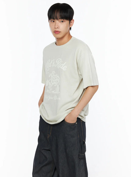Men's Graphic Print Tee IL510 Light beige side-angle close-up on male model hands in pockets showing Let's Ride cowboy graphic print detail