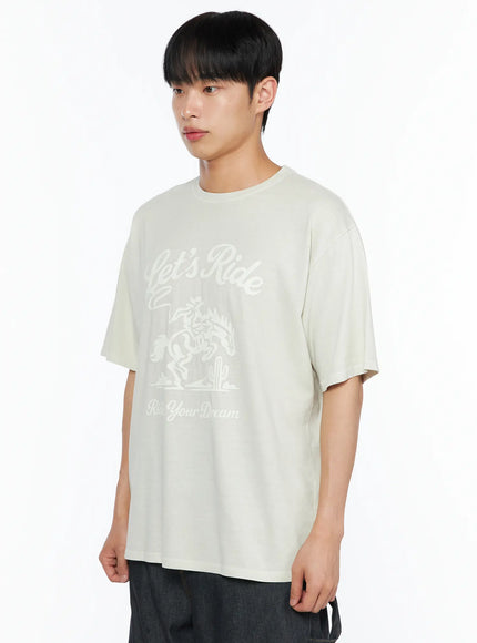 Men's Graphic Print Tee IL510 Light beige side-angle upper-body shot on male model gazing left showing oversized fit and tonal chest graphic