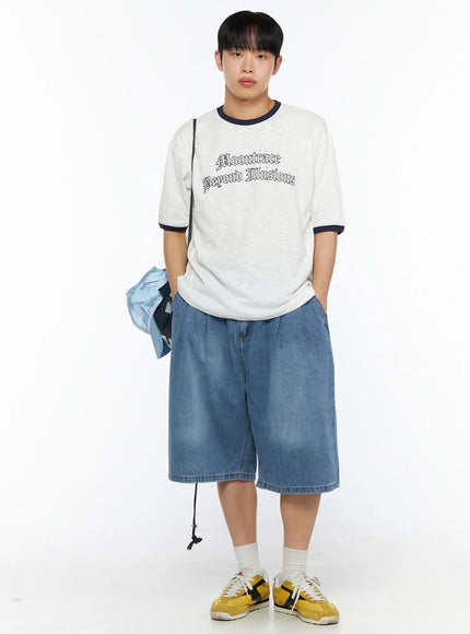 Men's Graphic Ringer T-Shirt IL510 White front full-body on male model holding blue cap, hands in pockets, styled with wide denim shorts and yellow sneakers