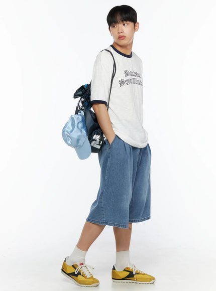 LEWKIN Men's Graphic Ringer T-Shirt IL510 White side-angle shot on male model wearing denim shorts, carrying drawstring bag and blue cap, slub cotton texture