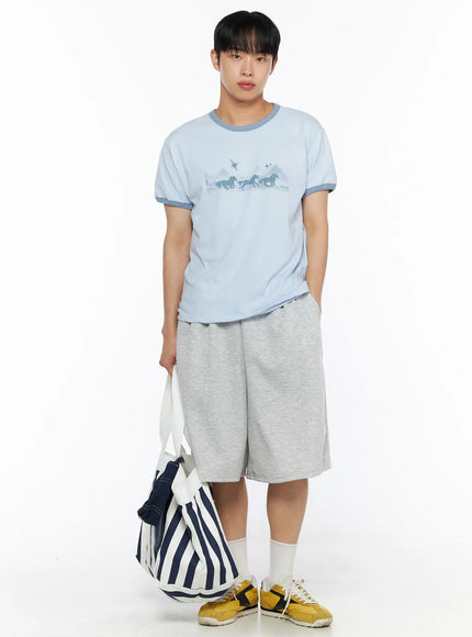 Men's Graphic Ringer Tee IL514 Light blue full-body front shot on male model holding striped tote bag at side, horse print graphic, contrast teal trim, yellow sneakers