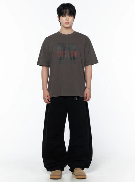Men's Graphic Short Sleeve T-Shirt IU523 dark brown full-body front on male model standing with wide-leg black pants and beige shoes