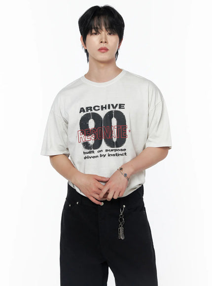 Men's Graphic Short Sleeve T-Shirt IU523 Light beige front close-up on male model with hands clasped, ARCHIVE 90 RESONATE print, oversized cotton tee