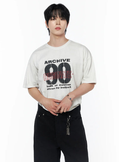 Men's Graphic Short Sleeve T-Shirt IU523 Light beige front close-up on male model with hands clasped, ARCHIVE 90 RESONATE print, oversized cotton tee