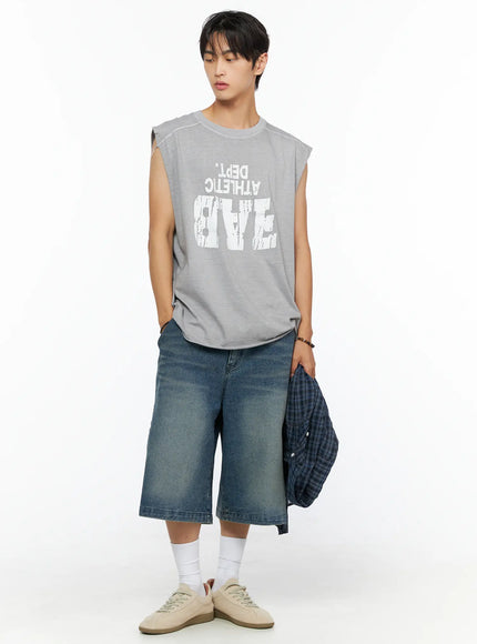 Men's Graphic Sleeveless Shirt IL520 Light gray front full-body model shot looking down holding plaid shirt at side with denim shorts