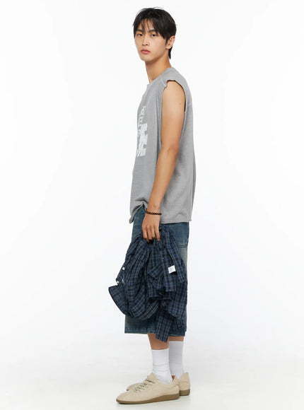 Men's Graphic Sleeveless Shirt IL520 Light gray side full-body model shot facing left holding plaid shirt showing length and silhouette