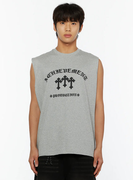 Men's Graphic Sleeveless Tee IL510 White front close-up on male model with chain necklace showing bold ACHIEVEMENT cross graphic print on white cotton sleeveless tee