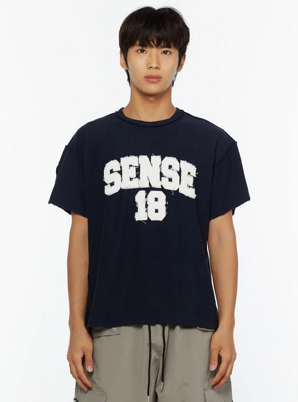 Men's Graphic Slogan T-Shirt IL509 Dark blue close-up front shot on male model highlighting SENSE 18 white flocked logo distressed texture and raw-edge neckline