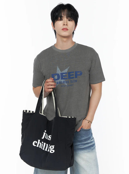 Men's Graphic Star T-Shirt IU523 Gray front shot on male model holding black just chilling tote bag at waist, DEEP BREATHE SLOW graphic tee detail