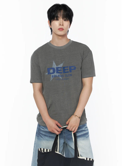 Men's Graphic Star T-Shirt IU523 Gray front crop shot on male model holding tote bag, blue DEEP BREATHE SLOW star graphic, white contrast stitching