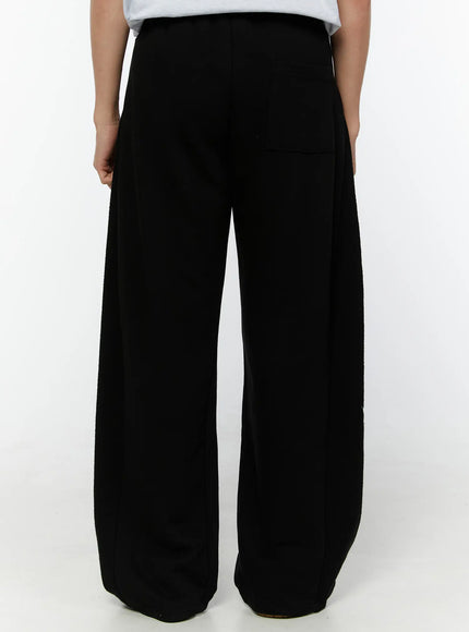 Men's Graphic Sweatpants (Black) IU529 Black back view on model, wide-leg fleece sweatpants with clean back panel, single back pocket, and textured fabric detail