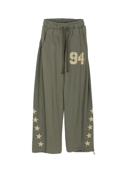 Men's Graphic Sweatpants (Dark Green) IU529 Dark green flat-lay front showing full silhouette, elastic drawstring waist, 94 graphic, wide legs with gold star-print fleece side panels