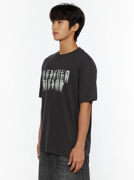 Men's Graphic T-Shirt IL515 Charcoal side view on male model, showcasing dropped shoulder seam and relaxed boxy fit with gothic chest print partially visible