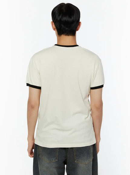 Men's Graphic T-Shirt IU529 Light beige back view on male model showing clean plain back black ringer crew neck and sleeve cuffs cotton jersey texture styled with dark jeans