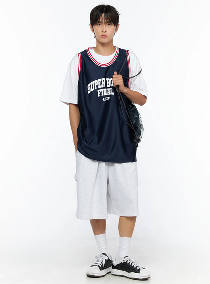 LEWKIN Men's Graphic Varsity Jersey IL515 Dark blue full-body front shot on male model holding drawstring bag, layered over white tee with gray shorts