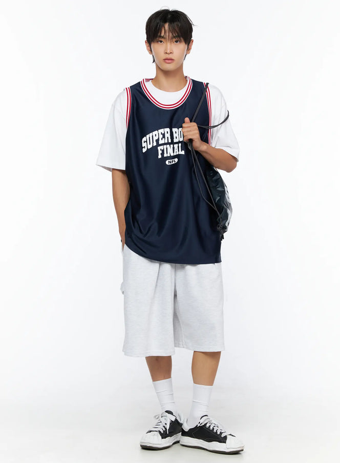 LEWKIN Men's Graphic Varsity Jersey IL515 Dark blue full-body front shot on male model holding drawstring bag, layered over white tee with gray shorts