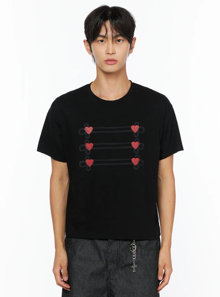 Men's Heart Graphic T-Shirt IL515 Black front close-up shot on male model cropped to torso showing red heart loop embroidery on black cotton